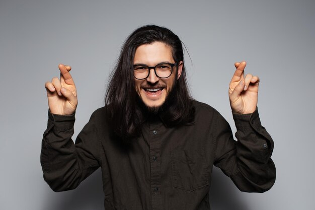 Portrait of young businessman with positive attitude crossing fingers