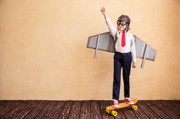 Photo portrait of young businessman with toy paper wings success creative and startup concept