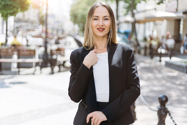 Portrait of a young businesswoman against the background of a city street