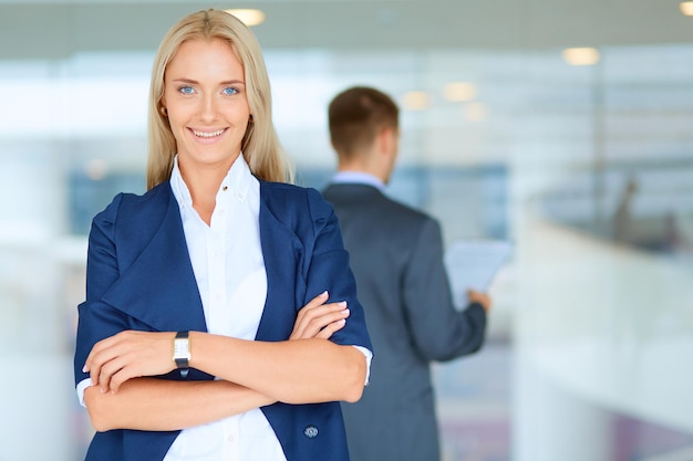 Photo portrait of young businesswoman in office with colleagues in the background