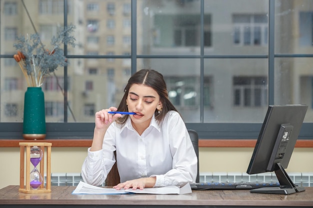 机に座って彼女のノートを見ている若い実業家の肖像画