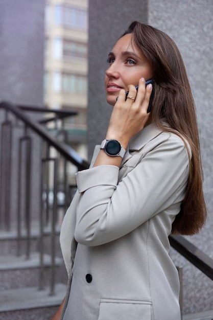 Portrait of a young businesswoman talking on the phone outdoors