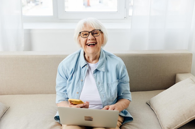 portrait of young businesswoman using laptop while sitting on sofa at home