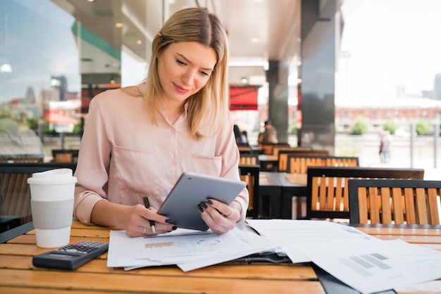 Портрет молодой коммерсантки, работающей с цифровым планшетом в кафе. Бизнес-концепция.