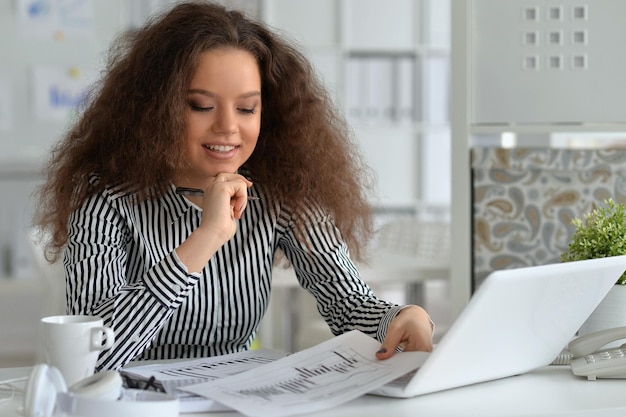 Photo portrait of young businesswoman working with laptop in the office