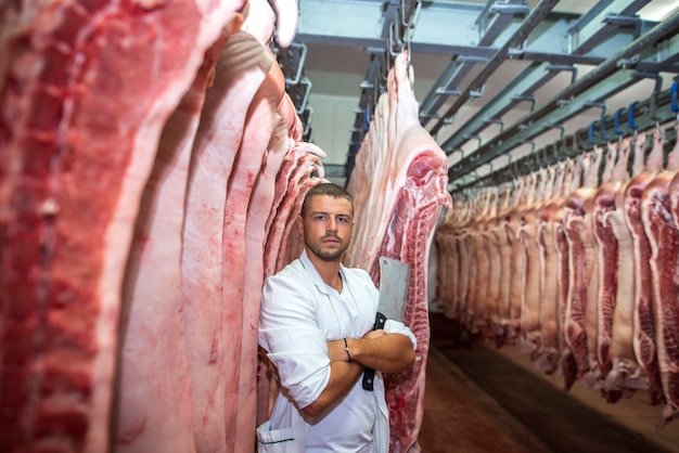 食肉加工業界でチョッパーナイフを保持している若い肉屋の肖像画。