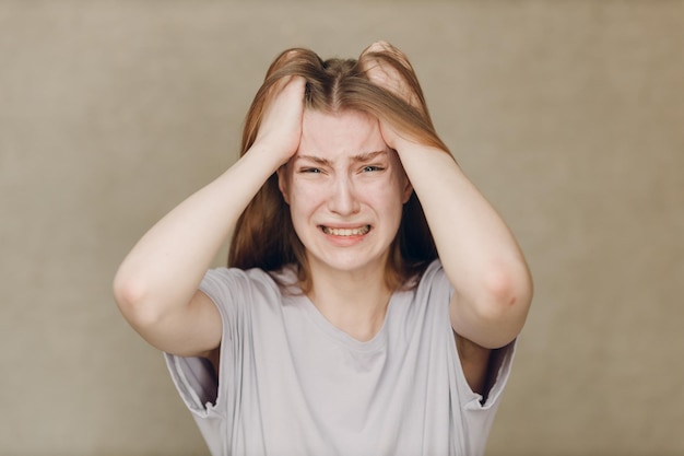 Portrait of young caucasian actress crying upset woman against beige background Acting test Casting film movie acting auditions