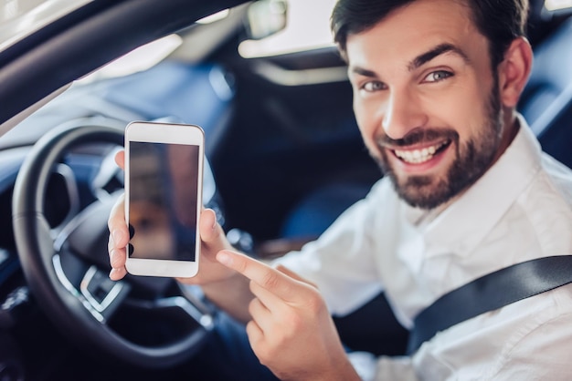 Portrait of young caucasian bearded businessman sitting in the car