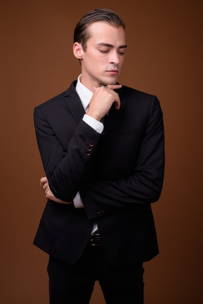 Portrait of young Caucasian businessman wearing suit and thinking