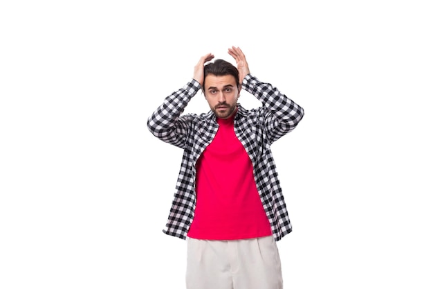 Portrait of a young caucasian handsome guy with a beard and styled hair dressed in a plaid shirt