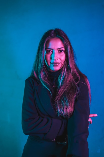 Portrait of young Caucasian model illuminated with blue and pink neons