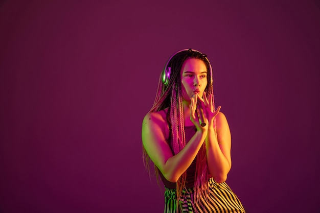 Portrait of young caucasian woman on pink background