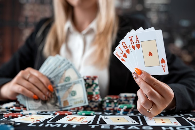 カジノでポーカーをプレイしているカードとチップを持つ若い白人女性の肖像画