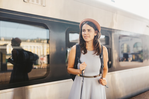 Женщина портрета молодая кавказская при зубастая улыбка стоя на поезде вокзала