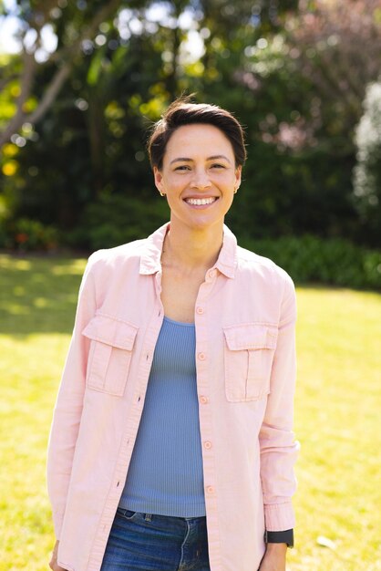 Portrait of young caucasian women wearing blue shirt and standing in the garden