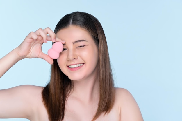 Portrait of young charming girl applying dry powder foundation on her face