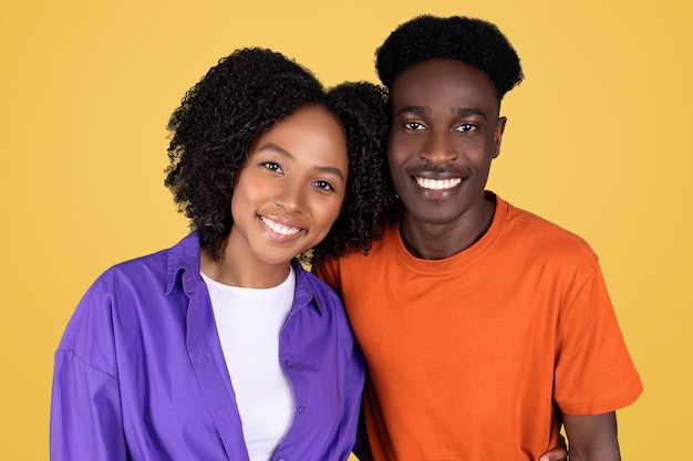 A portrait of a young cheerful couple with a woman in a purple blouse and a man in an orange shirt