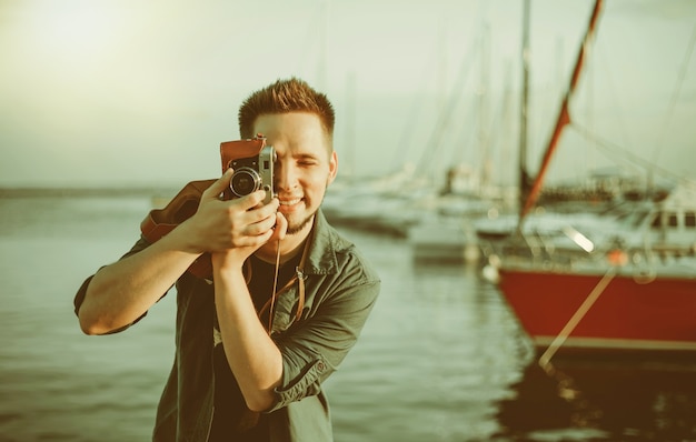 Foto ritratto di un giovane hipster allegro sullo sfondo del mare