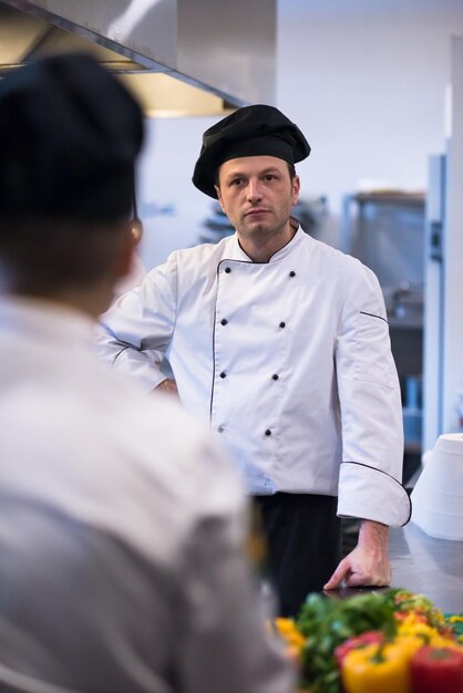 Portrait of young chef standing in commercial kitchen at\
restaurant