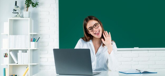 Portrait of a young confident and attractive female student with laptop computer in school classroom Online learning at school distance education