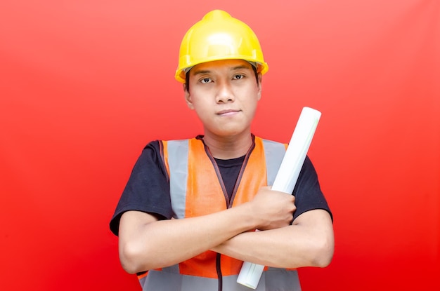 Portrait of a young confident engineer or construction worker in safety helmet and vest