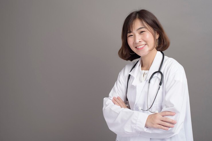 Photo 회색 배경 스튜디오에 격리된 자신감 있는 젊은 여성 의사의 초상화