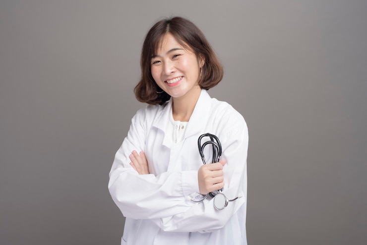 Photo 회색 배경 스튜디오에 격리된 자신감 있는 젊은 여성 의사의 초상화