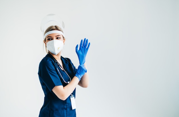 Portrait of young confident woman nurse hospital worker in medical protective mask isolated on white background.