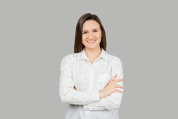 Portrait of a young confident woman with crossed arms smiling at the camera