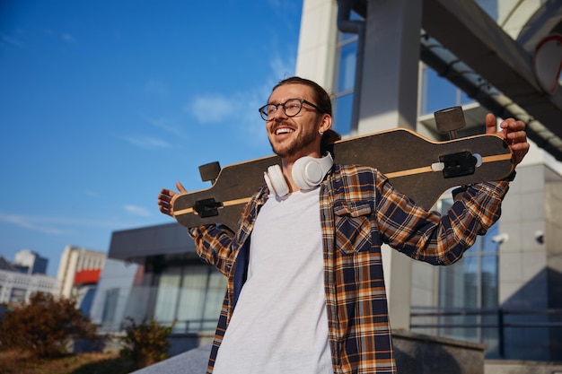 Photo portrait of young cool hipster man enjoying skateboarding hobby