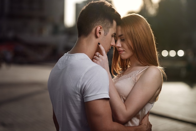 Portrait of young couple in love, enjoying the sunset in city.