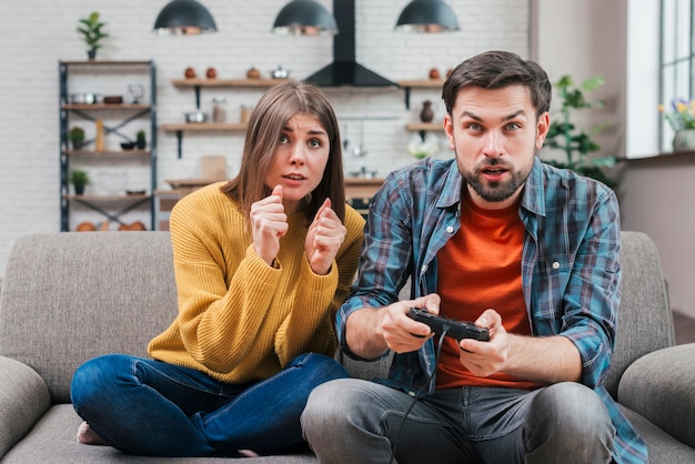 Photo portrait of young couple playing video game at home