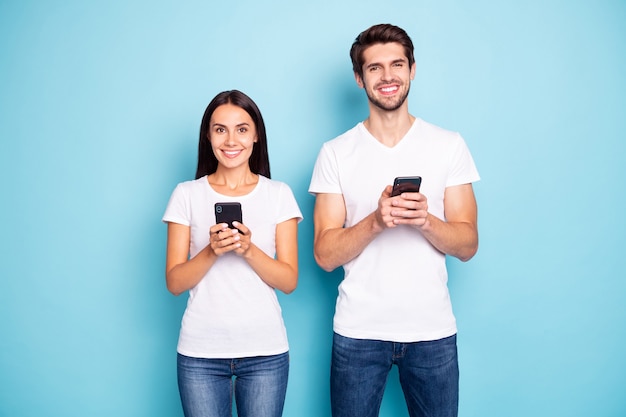 Portrait of young couple posing on blue color wall