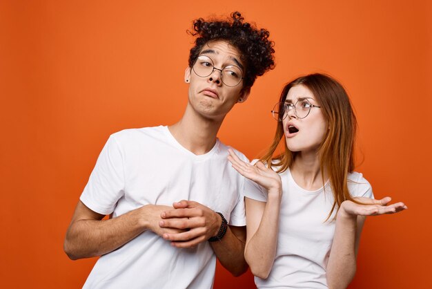 Portrait of young couple standing against orange background