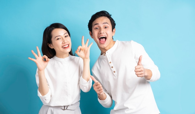 Portrait of young couple standing posing on blue wall