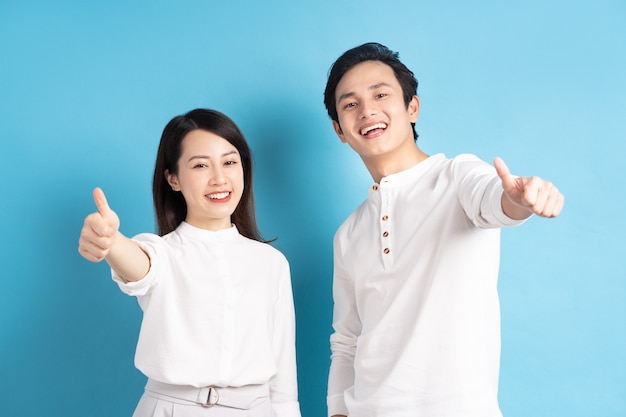 Portrait of young couple standing posing on blue wall