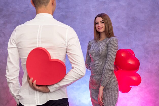 Portrait of young couple with red shape heart air balloons. Valentine's day celebration concept