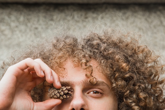 Portrait of a young curly haired guy in a summer park 