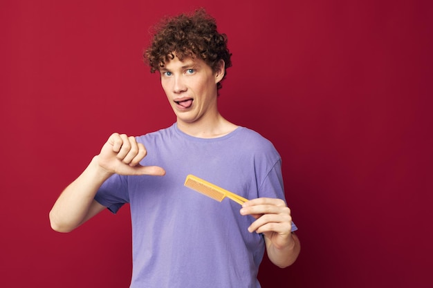 Portrait of a young curly man posing hairbrush personal care Youth style