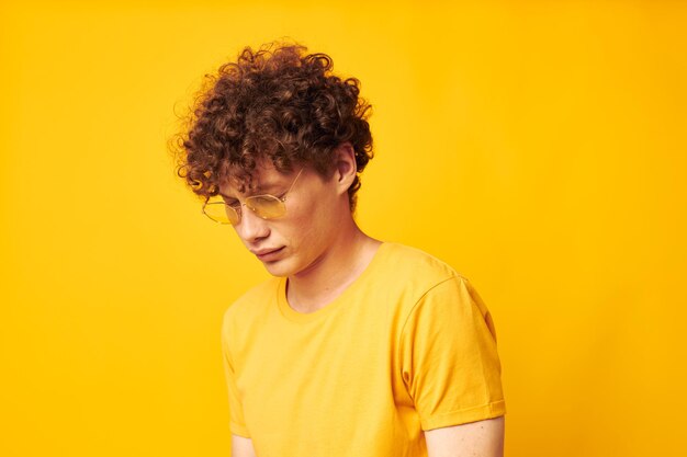 Photo portrait of a young curly man youth style glasses studio casual wear isolated background unaltered