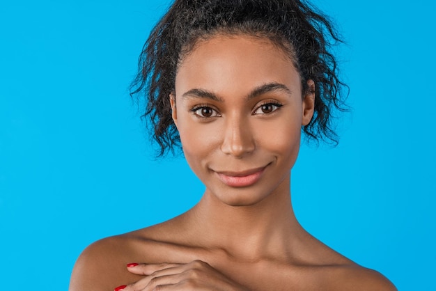 Portrait of young and cute african woman on blue background