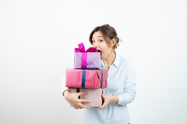 Photo portrait of a young cute girl holding present box with ribbon. high quality photo