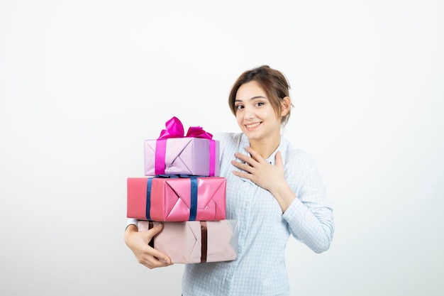 Portrait of a young cute girl holding present box with ribbon. High quality photo