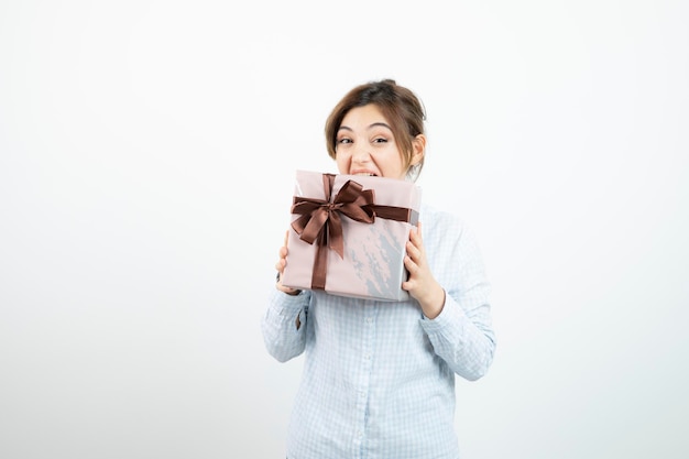 Portrait of a young cute girl holding present box with ribbon. High quality photo