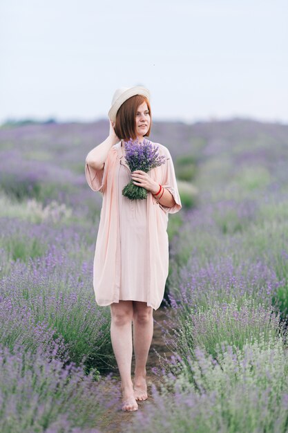 Portrait of a young cute girl in a pink dress in a lavender field