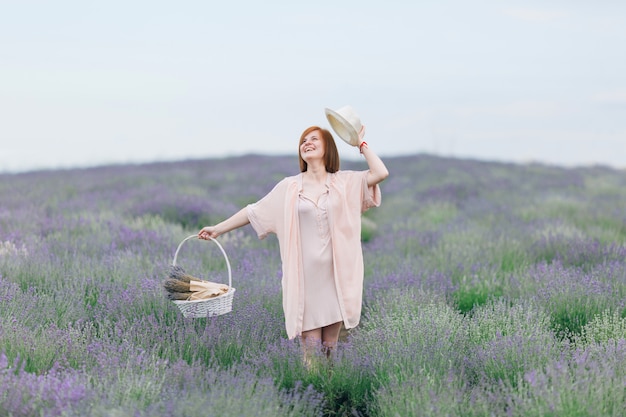 Portrait of a young cute girl in a pink dress in a lavender field