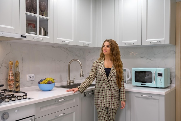 Portrait of young cute housewife in the kitchen interior