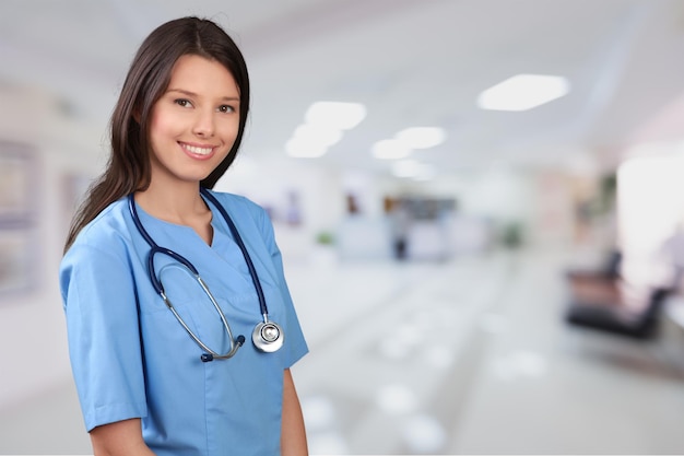 Portrait of young cute woman doctor in blue uniform with stethoscope