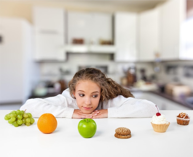 Portrait of young cute woman with food on kitchen background