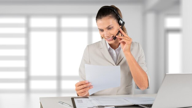 Portrait of young cute woman at work on office background